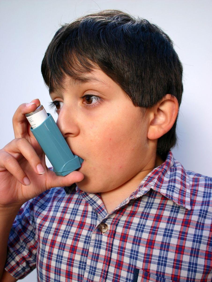 "Child using inhaler for asthma treatment and respiratory relief"