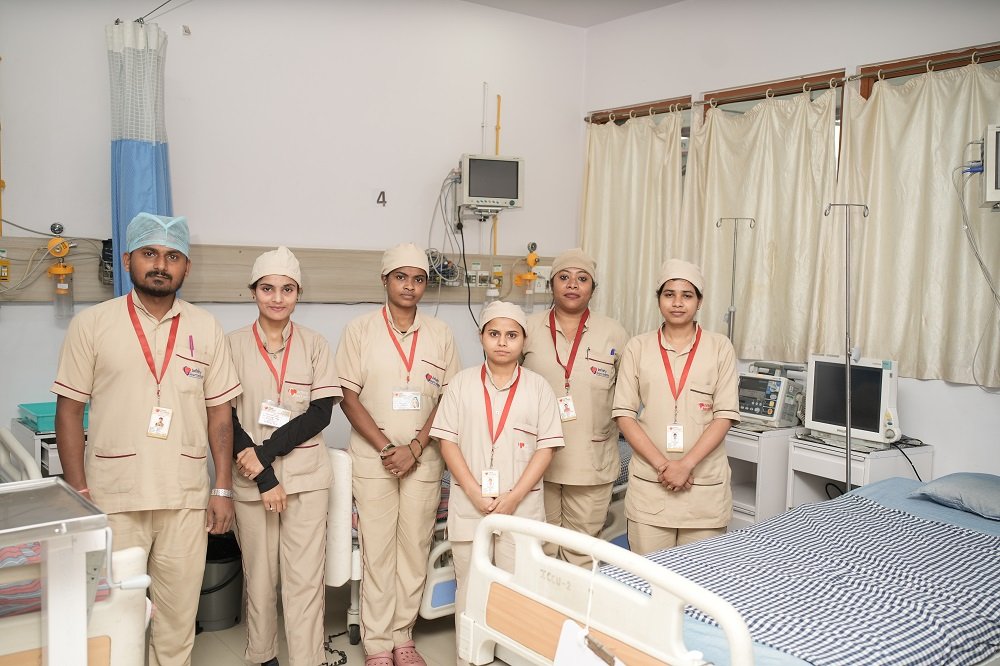 "Group of nursing and paramedical staff in beige uniforms at Infinity Heart Institute Jabalpur"