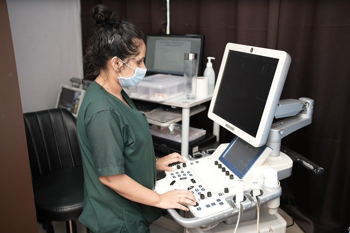 "Female sonographer operating hospital ultrasound machine for diagnostic imaging at Infinity Heart Hospital Jabalpur"