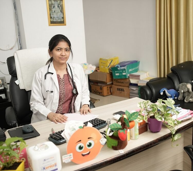 Dr. Reema Agrawal, pediatrician, seated at her office desk with stethoscope and patient files at Infinity Heart Institute Jabalpur