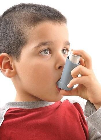"Young boy using asthma inhaler for respiratory relief and asthma management"