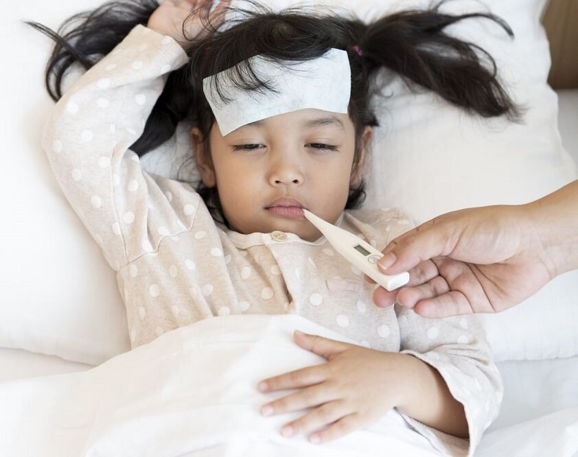 "Child receiving temperature check for fever at Infinity Heart Hospital Jabalpur"