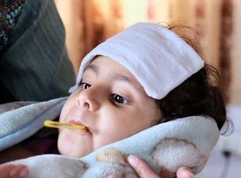 "Doctor caring for a sick child with head bandage at Infinity Heart Hospital Jabalpur"