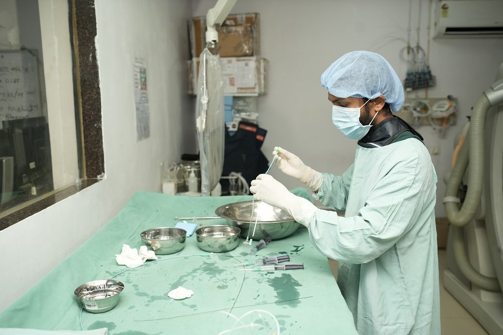 "Doctor prepares medical instruments for angiography at Infinity Heart Hospital Jabalpur"